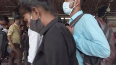 Salgın sırasında maskeyle Dadar tren istasyonunun köprüsünde yürüyen insanlar 19, Mumbai, Hindistan 2021