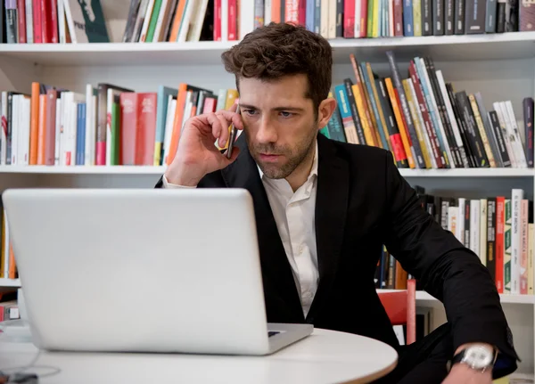 Man is working with computer and telephone at office with rack