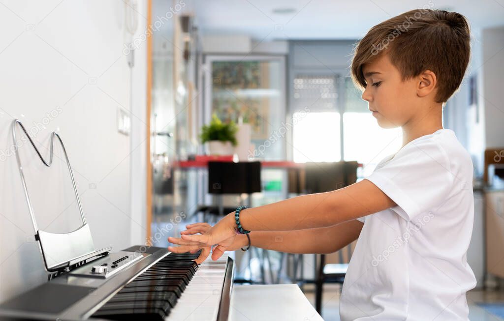 Child practices piano inside his house