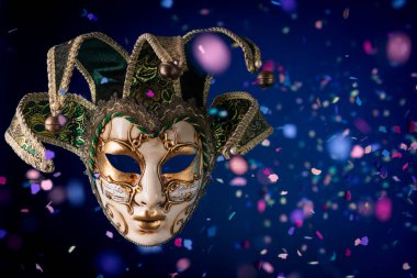 Uçan konfetiler arasında Venedik karnaval maskesi