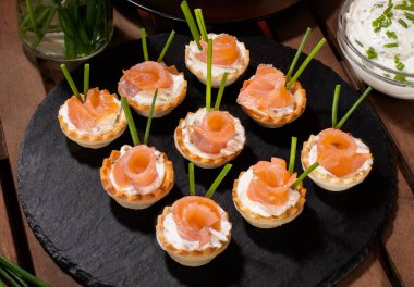 Masada peynirli somon tartları ve soslu frenk soğanı.