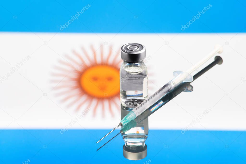 Vaccine concept with reflected and defocused Argentina country flag, selective focus on vaccine