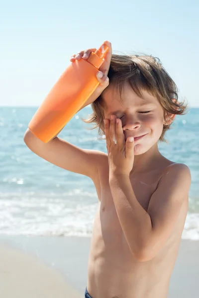 Çocuk elleri yüzünde güneş kremi uygulayın