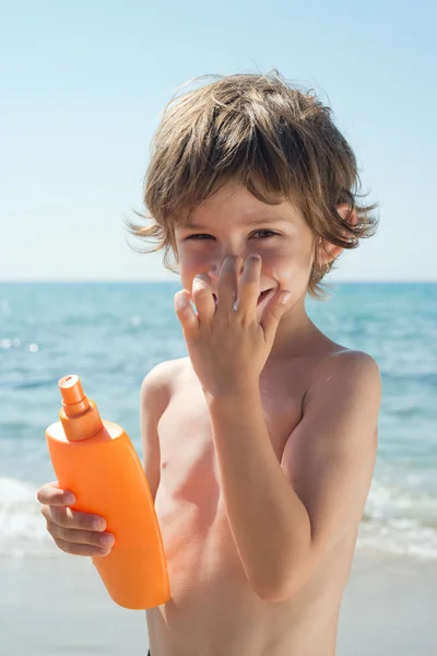 Çocuk sahilde eliyle burnuna güneş krem uygulamak
