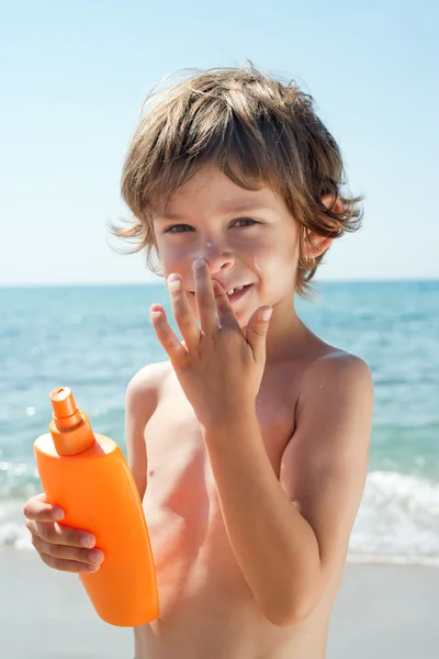 Child apply sun cream on his nose with hands — Stock Photo, Image