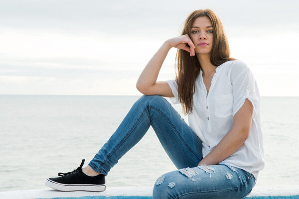 young woman with sea to the bottom watching to camera