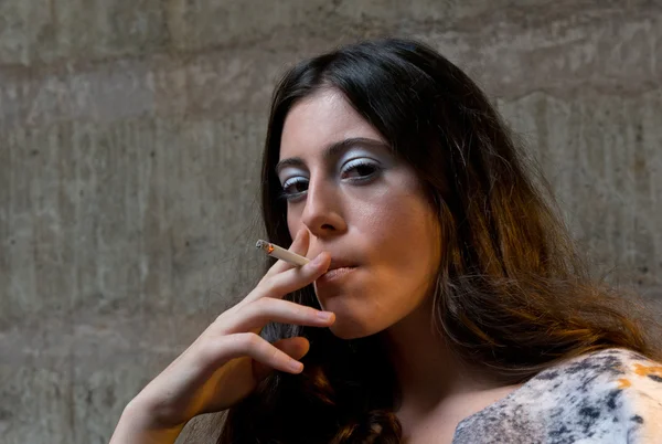 Молодая женщина курит сигарету — стоковое фото