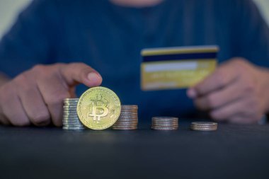 Elinde altın Bitcoin ve kredi kartı olan bir adam. Bitcoin ile para kazanmak, dijital para birimi para yatırım konsepti, engelleme zinciri transferi.