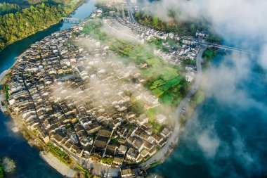 İlkbaharda, Çin 'in Jiangxi Eyaleti' nin Wuyuan kentinin kırsal arazisi teraslı yamaçların tepesinde çiçek açan kolza çiçeği manzarası..