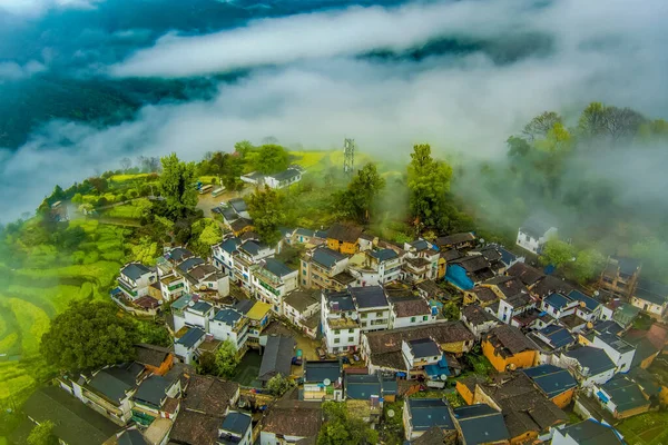 İlkbaharda, Çin 'in Jiangxi Eyaleti' nin Wuyuan kentinin kırsal arazisi teraslı yamaçların tepesinde çiçek açan kolza çiçeği manzarası..
