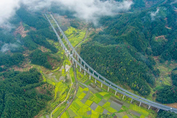 İlkbaharda, Çin 'in Jiangxi Eyaleti' nin Wuyuan kentinin kırsal arazisi teraslı yamaçların tepesinde çiçek açan kolza çiçeği manzarası..