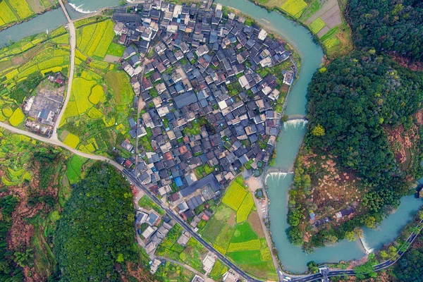 İlkbaharda, Çin 'in Jiangxi Eyaleti' nin Wuyuan kentinin kırsal arazisi teraslı yamaçların tepesinde çiçek açan kolza çiçeği manzarası..