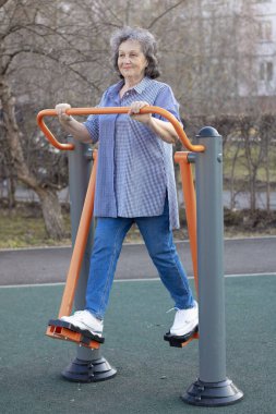 Büyükannem egzersiz yapıyor. Parktaki gri saçlı yaşlı kadın.