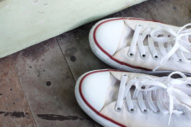 Çift izole ahşap zemin üzerinde beyaz spor ayakkabı