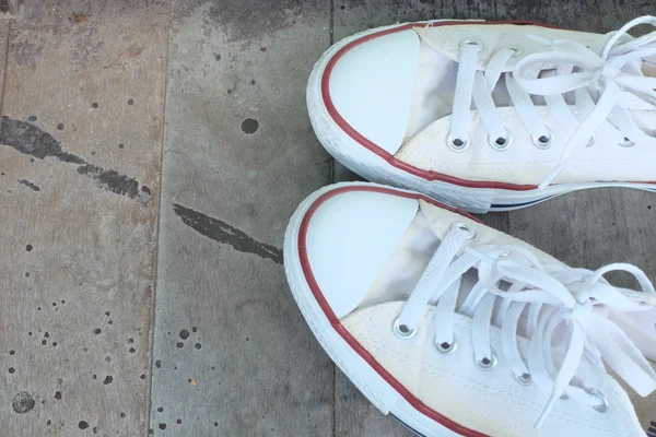 Pair of  white sneakers isolated on wooden floor — Stock Photo, Image