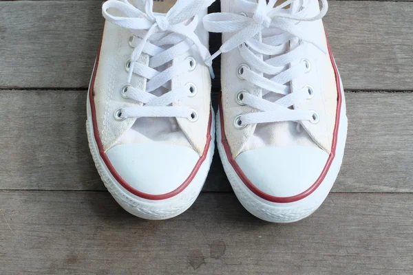 Pair of  white sneakers isolated on wooden floor — Stock Photo, Image