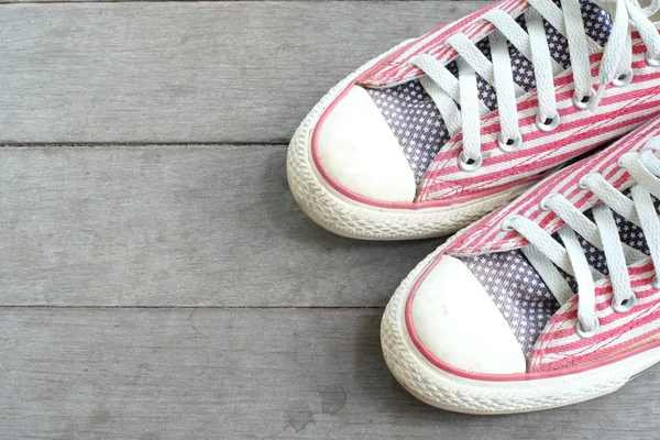 Pair of red sneakers isolated on wooden floor — Stock Photo, Image