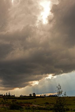Yoğun kümülüs bulutları arasında parıldayan güneş ışınları Kolombiya 'nın orta kesimindeki And Dağları' nın eteklerinde, öğleden sonra.