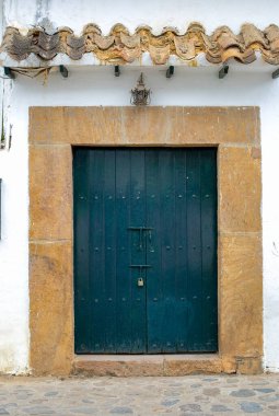 Kolombiya 'nın orta kesimindeki And Dağları' ndaki sömürge şehri Villa de Leyva 'nın bir sokağında büyük mavi bir kapı..