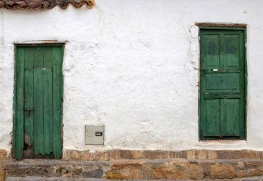 Kolombiya 'nın orta kesimindeki And Dağları' ndaki sömürge kasabası Villa de Leyva 'nın iki eski ve hasarlı yeşil kapısı..