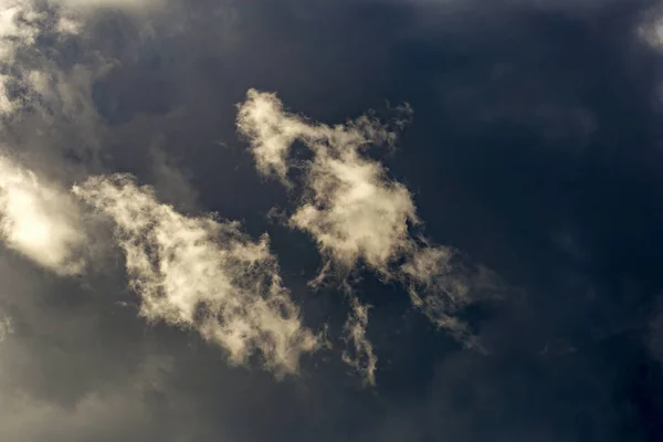 Zwei Kleine Sanfte Wolken Ziehen Vor Einer Sehr Grauen Wolke — Stockfoto