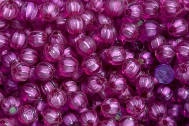 Mücevher ve aksesuar üretiminde kullanılan değişik şekillerde renkli boncukların makro fotoğrafları..