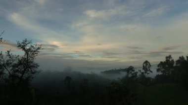 Yumuşak, yavaş bulutlar ve yoğun bir sis gündoğumunda Orta Kolombiya 'nın doğu Andean dağlarının batısında, Iguaque doğal rezervi yakınlarında ilerliyor..