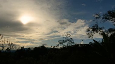 Güneş, Orta Kolombiya 'nın doğu Andean dağlarının batısında, yumuşak ve karanlık bulutların ardında batıyor..