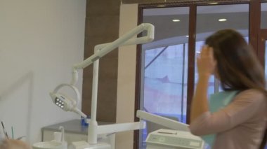 Diş Hekimi Bir Müşteri Kadın Maske Bir Sandalye Doktor Üzerinde Yatıyor Onun Göğüs Diş Kliniğinde Kağıt Peçete bir Hasta Kadının Dişlerini İncelemek için gidiyor