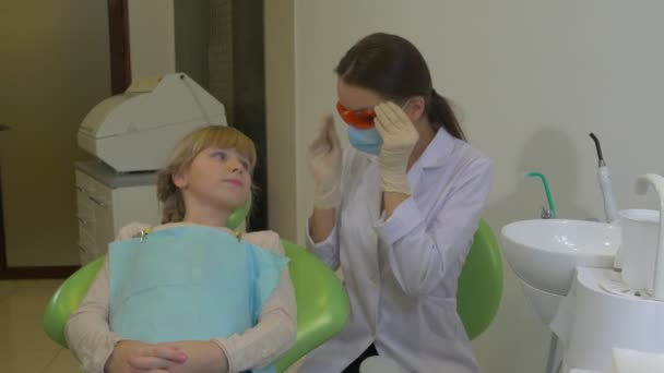 Diş Hekimi Uv Diş Lambası Kullanarak Başparmak Hasta Doktor Diş Hekimi ne ziyaret diş tedavi odasında bir hasta genç kız bir diş tedavi olduğunu göster — Stok video