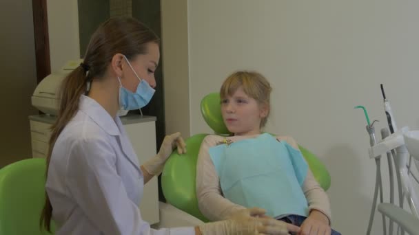 Dentista pone una mano en el hombro de un paciente Chica se queja de un dolor de muelas toca una mejilla Examinando los dientes de un paciente Visita al Hospital Dentista — Vídeos de Stock