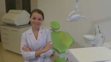Laboratuvar Önlük Diş Hekimi Genç Kadın Doktor Bir Koğuşta Sandalyede Oturan Gülümseyen Kamera Diş Hekimi Makine Diş Lambası Yeşil Sandalye Diş Kliniği bakıyor
