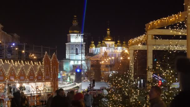 Pessoas caminhando na Feira de Natal Kiev Praça Sophia Catedral de Sophia Noite de Ano Novo em uma Praça Sophia Kiev Praça brilhantemente iluminada — Vídeo de Stock