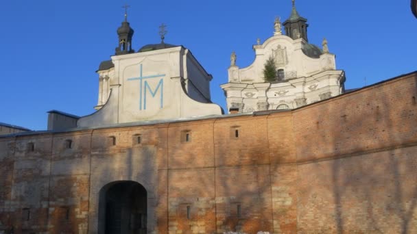 Bir çıplak ayakla Carmelites'sinin Manastırı Berdiçev koruyucu duvarlar kuleleri bir Barok tarzı Katolik Vintage antik yapı güneşli bir gün mavi gökyüzü Ukrayna için kemer — Stok video