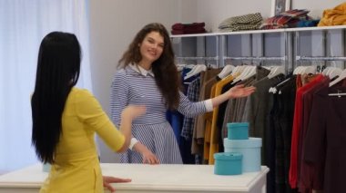 Gülümseyen istemcisinde bir butik bir kırmızı bluz kadın giyim Dükkanı satıcı olduğu bir istemci kadın için bir elbise bluz çalışır arıyor seç için teklif satıcı