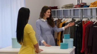 İstemci gülümseyen bir butik giysilerle almak için bir istemci kadın için bir bluz bluz kadın giyim Dükkanı satıcı, arıyor seç için teklif satıcı gerek