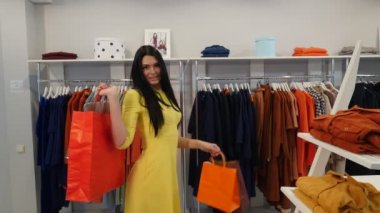 Kadın, kadın giyim mağazasında poz veriyor, kadın giyim mağazasında mutlu esmer kadın butik kıyafetler alıyor, Trempel 'de.