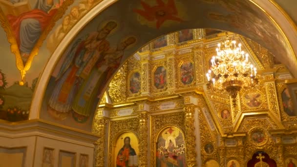 Igreja Ortodoxa Padres Dormição Catedral Frescos Ícones em Quadros Dourados Pessoas com Halos Multidão de Homens está andando sentado em torno de uma mesa Clero Vestuário — Vídeo de Stock