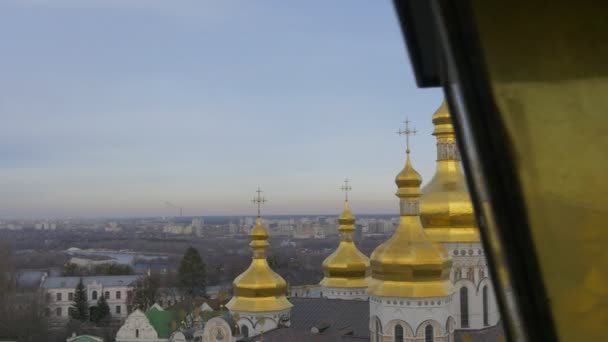 Cúpulas douradas com cruzes de santa dormição Kiev-Pechersk Lavra Dormition Cathedral Kiev White Walls Green Roof Cityscape em um horizonte Dia nublado — Vídeo de Stock