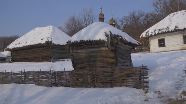 Church Behind a Rustic Huts Cupolas Winter Snow Wattle Fence Church of the Holy Michael the Archangel Towers Cupolas Pirogovo Forest is Around a Village — Stock videók