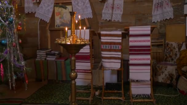 Płonące świece Kościół Paraskeva Christmas haftowane ręczniki są stałe na teh ikon Pirogovo wnętrz obrazy w złote ramki nowy rok drzewo Ukraina — Wideo stockowe