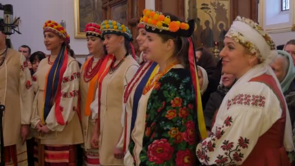 女の子の寮大聖堂グループウクライナヘアドレス聖山ラブラクリスマスのお祝いの女性はマイクでクリスマスソングを歌っています — ストック動画