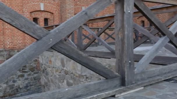 Murs de briques rouges d'un château Radomysl Clôture en bois dans une cour Fondation pierreuse Panorama Parc paysager Près du château de Radomysl Ukraine Ensoleillé 