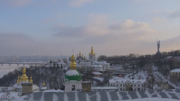 Kiev-pechersk lavra linkes Ufer des Dnjepr Krähen fliegen paton Brücke Mutterland Denkmal kiev Stadtbild Winter schneerosa Wolken ona blauer Himmel — Stockvideo