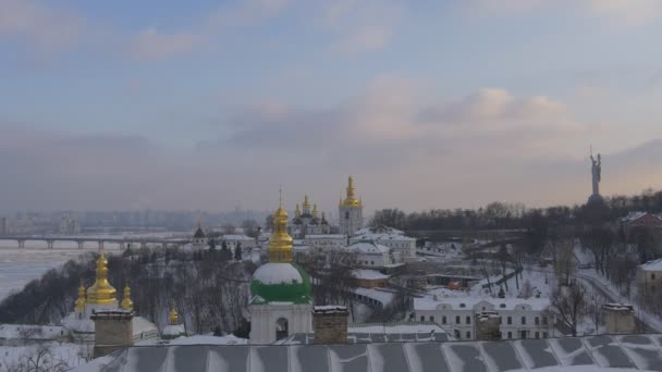 Zwarte kraaien vliegen op Kiev-Pechersk Lavra Left Bank van Dnjepr Paton brug Motherland Memorial Kiev Cityscape winter Sneeuwwolken op blauwe hemel — Stockvideo