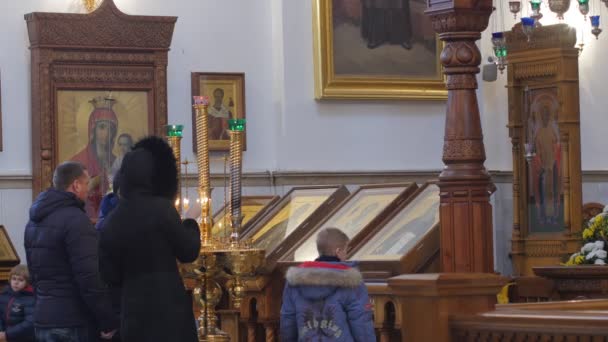 Persone Kid attraversando se stessi Natale Lavra Dormition Cattedrale Ucraina La gente sta pregando alle icone candele stanno bruciando immagini Decorazione in legno dorato — Video Stock