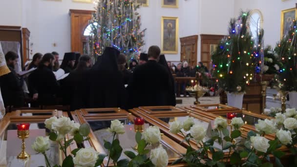 Gruppo di clero Natale Holy Mountain Lavra Dormition Cathedral Ucraina Uomini in indumenti neri stanno cantando Le persone stanno ascoltando alberi di Capodanno decorati — Video Stock