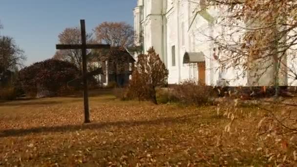 Cruz de madeira no pátio Mgar Transfiguração Mosteiro masculino Folhas amarelas em um terreno Poltava Região Transfiguração Catedral Ucrânia Dia ensolarado Outono — Vídeo de Stock