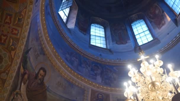 Clergy w służbie w Trójcy Jonah's Monastery święto Mary Dormition Kijów duchowieństwo w odzieży serwisowej stoi na obrazy fresków świece — Wideo stockowe