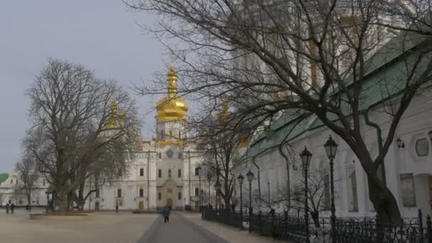 Pessoas na Igreja Paredes Brancas Cúpulas Douradas Dormição Sagrada Kiev-Pechersk Lavra Dormition Cathedral Exterior de uma Igreja Ortodoxa High Bell Tower — Vídeo de Stock